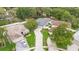 Aerial view of a home with a driveway and a pool, situated among mature trees and fenced backyard at 105 Golfside Cir, Sanford, FL 32773