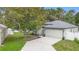 Charming home featuring a well-manicured lawn, mature trees, and a two-car garage at 105 Golfside Cir, Sanford, FL 32773