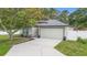 Charming single Gathering home with a two-car garage, landscaped yard, and walkway leading to the entrance at 105 Golfside Cir, Sanford, FL 32773