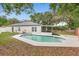 Backyard showcasing a private swimming pool with surrounding patio and lush landscaping at 105 Golfside Cir, Sanford, FL 32773