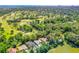 Wide angle aerial shot of home on golf course near the water with city views in the background at 105 Riviera Estates Blvd, Ormond Beach, FL 32174