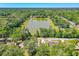 Aerial image featuring a serene pond and the property nestled amidst lush greenery and mature trees at 105 Riviera Estates Blvd, Ormond Beach, FL 32174