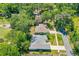 Aerial view of the property surrounded by mature trees, with a well-maintained lawn and neighborhood streets at 105 Riviera Estates Blvd, Ormond Beach, FL 32174
