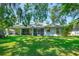 Expansive backyard featuring a well-manicured lawn and screened lanai, perfect for outdoor living at 105 Riviera Estates Blvd, Ormond Beach, FL 32174