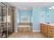 Relaxing bathroom with a tiled surround tub, walk-in shower, and natural wooden vanity at 105 Riviera Estates Blvd, Ormond Beach, FL 32174