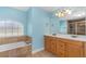 Spacious bathroom features a large window above the tub, enhancing natural light, and double sinks at 105 Riviera Estates Blvd, Ormond Beach, FL 32174