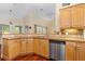Well-lit kitchen with wood cabinetry, stainless steel dishwasher, and a tiled countertop at 105 Riviera Estates Blvd, Ormond Beach, FL 32174