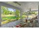 Screened-in lanai with a view of a lush green lawn and mature trees, perfect for outdoor relaxation and entertaining at 105 Riviera Estates Blvd, Ormond Beach, FL 32174
