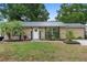 Charming home with a well-manicured lawn, palm tree, and decorative accents by the front door at 1135 5Th St, Orange City, FL 32763