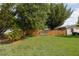 Spacious backyard with lush green grass, mature trees, and a wooden fence for privacy at 1148 Briarwood Ave, Deltona, FL 32725