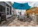 Relaxing patio area with grill, dining table, and a large blue umbrella at 1148 Briarwood Ave, Deltona, FL 32725