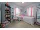 Bright bedroom with white furniture, pink accents, a single bed, decorative elements, and seashell artwork at 1148 Briarwood Ave, Deltona, FL 32725