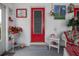 Charming entrance features a bright red door, white shelving, and tropical décor at 1148 Briarwood Ave, Deltona, FL 32725