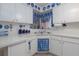 Well-lit kitchen with white cabinetry and sink area, accented by blue and white decor at 1148 Briarwood Ave, Deltona, FL 32725