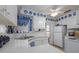 Bright kitchen with white cabinets, sink, ceiling fan, and appliances adorned with blue decorative accents at 1148 Briarwood Ave, Deltona, FL 32725