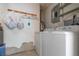 Functional laundry area features a washer, dryer, storage and hanging rack at 1148 Briarwood Ave, Deltona, FL 32725