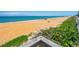 View of the beach with wooden rails, and green plants on the edge at 1167 Ocean Shore Blvd # 110, Ormond Beach, FL 32176