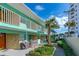 Exterior view of building with patio, outdoor grill and lush landscaping at 1167 Ocean Shore Blvd # 110, Ormond Beach, FL 32176