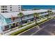 Charming beach condo featuring light blue paint, a white railing, and well-maintained landscaping overlooking the ocean at 1167 Ocean Shore Blvd # 110, Ormond Beach, FL 32176