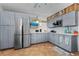 Updated kitchen with gray cabinetry, stainless steel appliances, and tile flooring at 1167 Ocean Shore Blvd # 110, Ormond Beach, FL 32176