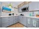 Modern kitchen with gray cabinets, stainless steel appliances, and white countertops at 1167 Ocean Shore Blvd # 110, Ormond Beach, FL 32176