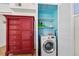 A compact laundry area featuring a modern washer and organized storage shelving at 1167 Ocean Shore Blvd # 110, Ormond Beach, FL 32176