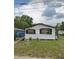 Exterior of a one-story house with white siding and black shutters surrounded by a grassy lawn at 1228 S Parsons Ave, Deland, FL 32720