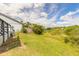 Spacious backyard with a pond view and stairs to a wooden deck, under a bright blue sky at 1229 Saddleback Ridge Rd, Apopka, FL 32703