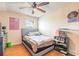 Cozy bedroom with wood floor, ceiling fan, poster, art, and comfortable-looking bed at 1229 Saddleback Ridge Rd, Apopka, FL 32703