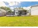 Exterior backyard view of a home with a screen porch, and wood deck with a spacious lawn at 1229 Saddleback Ridge Rd, Apopka, FL 32703