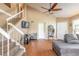 Living room featuring a high ceiling, fan, wood floors, staircase, and a comfortable gray couch at 1229 Saddleback Ridge Rd, Apopka, FL 32703