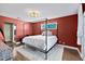 Elegant bedroom with a luxurious four-poster bed, wood-look tile flooring, and stylish lighting fixture at 1317 Suwanee Rd, Daytona Beach, FL 32114