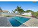 Backyard pool is surrounded by a paved patio, complemented by lush greenery and palm trees, perfect for outdoor enjoyment at 1317 Suwanee Rd, Daytona Beach, FL 32114
