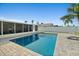 Backyard pool is surrounded by a paved patio, complemented by lush greenery and palm trees, ideal for outdoor enjoyment at 1317 Suwanee Rd, Daytona Beach, FL 32114