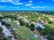 Expansive aerial perspective showcasing a community with lush green landscaping, mature trees, and a nearby golf course at 1371 Merrifield Ct, Deltona, FL 32725