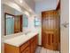 Bathroom features a vanity with wood cabinets and a large mirror at 1371 Merrifield Ct, Deltona, FL 32725