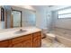 Bathroom features a vanity with wood cabinets, a bathtub and a large mirror at 1371 Merrifield Ct, Deltona, FL 32725