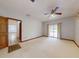 Bright bedroom with a ceiling fan, window, neutral carpet, and a door leading to another room at 1371 Merrifield Ct, Deltona, FL 32725