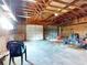 Spacious garage featuring exposed wood beams, concrete floor, and two garage doors at 1371 Merrifield Ct, Deltona, FL 32725