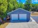 Exterior shot of a two-car garage, featuring gray siding and a concrete driveway at 1371 Merrifield Ct, Deltona, FL 32725