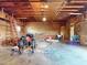 Large garage with exposed wood beams, concrete floor, and ample space for storage at 1371 Merrifield Ct, Deltona, FL 32725