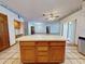 Open kitchen features an island with natural cabinets, tile floors, and recessed lighting at 1371 Merrifield Ct, Deltona, FL 32725