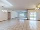 Spacious living room featuring tile floors, a ceiling fan, and a sliding glass door at 1371 Merrifield Ct, Deltona, FL 32725