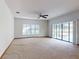 Living room features carpet, ceiling fan, and sliding glass doors with natural lighting at 1371 Merrifield Ct, Deltona, FL 32725
