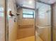 Tiled shower features glass doors, a safety bar, and a window for natural light at 1371 Merrifield Ct, Deltona, FL 32725