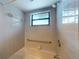 Shower features tiled walls, a safety bar, and a window for natural light at 1371 Merrifield Ct, Deltona, FL 32725
