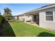 Lush backyard featuring a covered patio, manicured lawn, and privacy hedge at 1374 Red Clover Ln, Deland, FL 32724