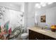 Bright bathroom featuring a decorative shower curtain, granite countertop, and modern fixtures at 1374 Red Clover Ln, Deland, FL 32724