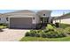 Charming single Gathering home featuring a two car garage, neutral paint, manicured lawn, and lovely landscaping at 1374 Red Clover Ln, Deland, FL 32724