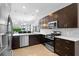 Open kitchen with granite countertops, stainless steel appliances, dark wood cabinetry, and recessed lighting at 1374 Red Clover Ln, Deland, FL 32724